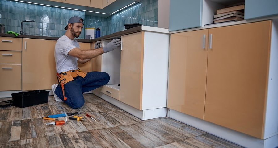 worker installing kitchen cabinet