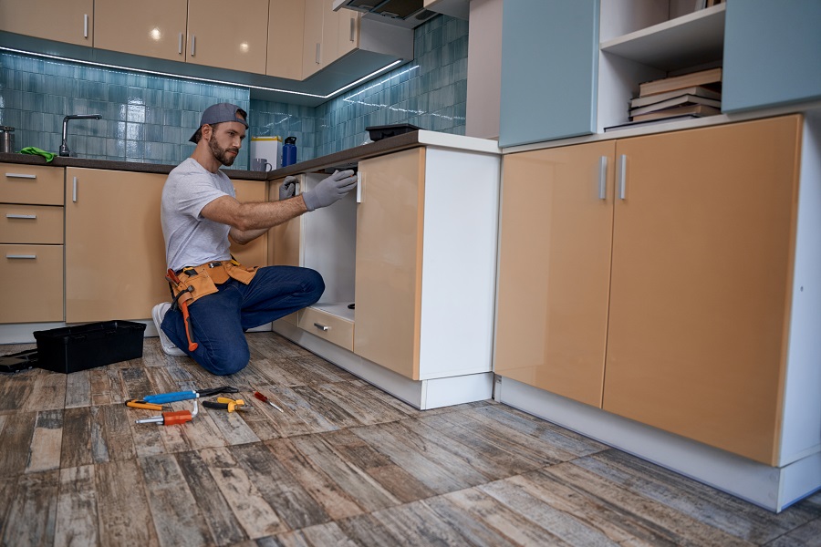 worker installing kitchen cabinet